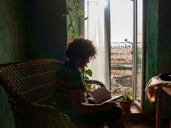 Woman reading book white sitting on seat at home