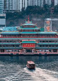 Boat in river with city in background