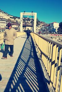 Shadow of man on bridge in city