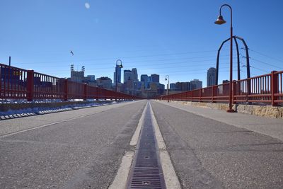 Surface level of bridge against clear blue sky during sunny day