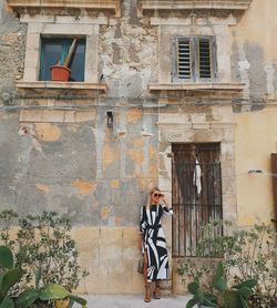 Woman standing by building