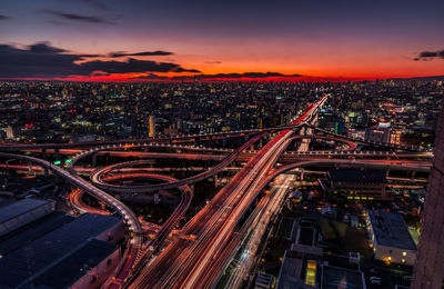 High angle view of bridge over cityscape at night