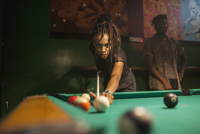 A young woman playing pool.