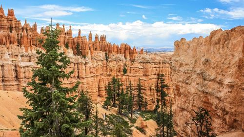 Scenic view of rock formations against cloudy sky