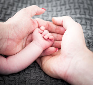 Cropped image of family stacking hands