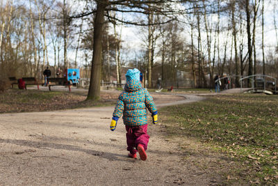 Rear view of boy walking on field