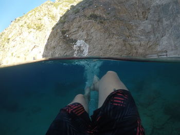 Low section of man swimming in sea