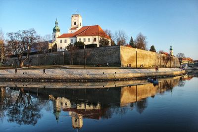 Reflection of building on river against sky