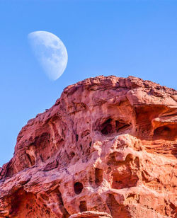 Low angle view of rock formation against clear blue sky