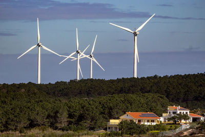 Windmills on field against sky