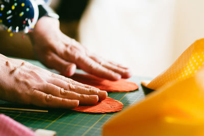 Cropped hands of person touching objects at table