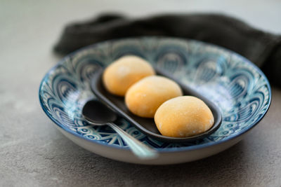 Yellow japanese mochi in rice dough and on a pattern blue plate background. traditional dessert.