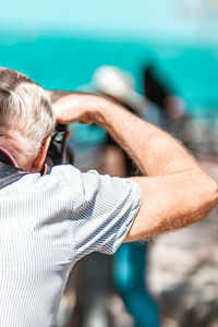 Rear view of man photographing outdoors