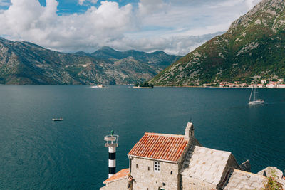 Scenic view of sea by mountains against sky