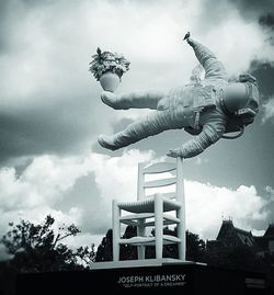 Low angle view of man jumping against sky