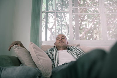 Man lying down on sofa at home