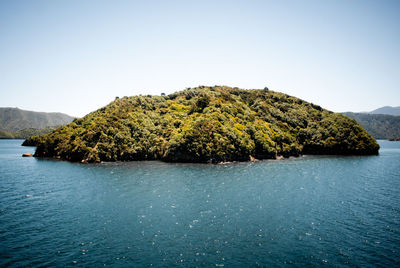 Scenic view of sea and mountains against clear sky