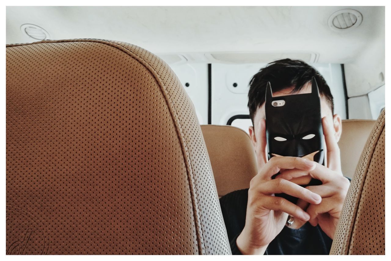 YOUNG WOMAN USING MOBILE PHONE IN MIRROR