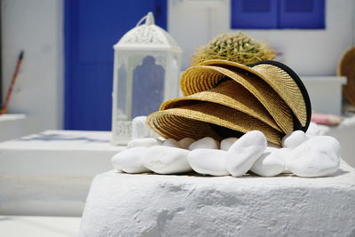 Straw hats and pebbles against house