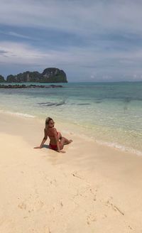 Woman at beach against sky