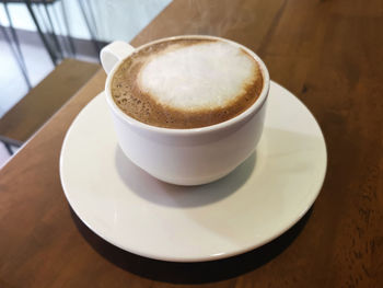 Hot coffee in a white cup on table