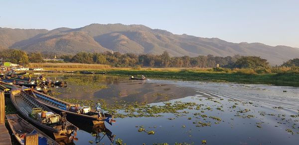 Scenic view of lake by mountains against sky