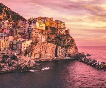 Scenic view of sea by buildings against sky