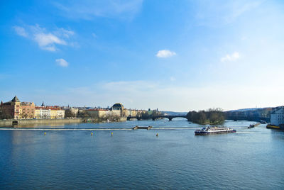 Boats in river against buildings in city