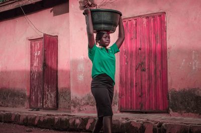 Rear view of woman carrying water on her head