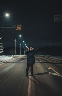 Full length of man standing on road at night