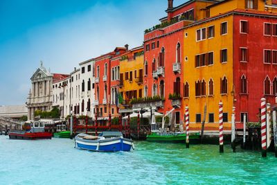 Boats moored on canal against buildings in city