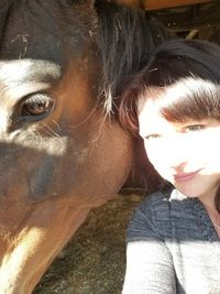 Close-up portrait of young woman with horse