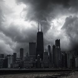 Skyscrapers in city against cloudy sky
