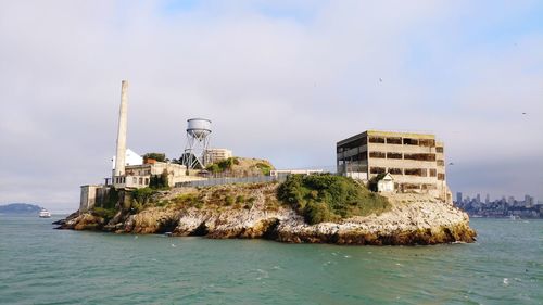 Built structure by sea against sky