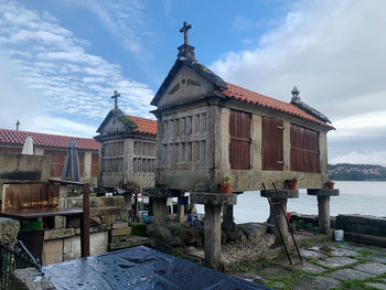 Old building by water against sky