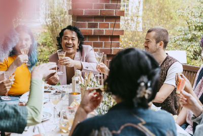 Happy friends of lgbtq community toasting drinks during party in back yard