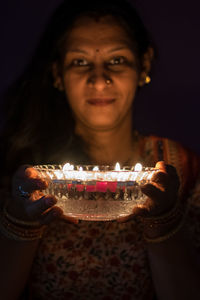 Close-up of mid adult woman against black background