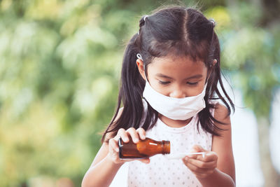 Close-up of girl taking syrup in spoon