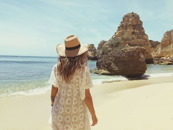 Rear view of woman standing at beach