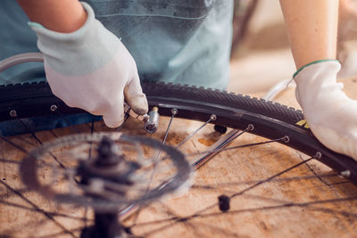 Midsection of man repairing bicycle tire