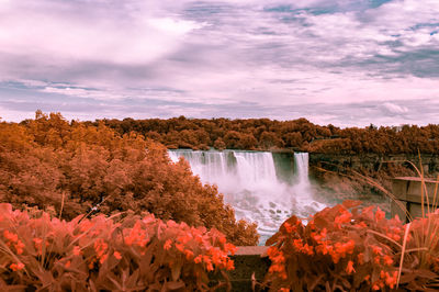 Scenic view of niagara falls against cloudy sky during sunset