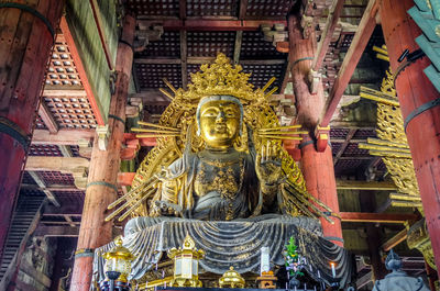 Low angle view of statue against temple building