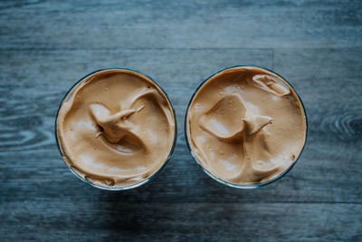 Overhead view of whipped coffee on wood table