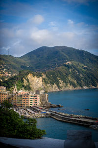 Aerial view of townscape by sea against sky