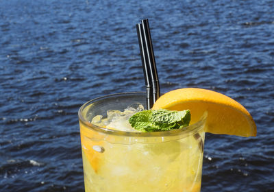 Close-up of drink on glass against water