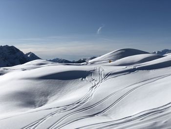 Scenic view of snow covered mountains against sky