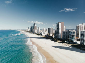 Sea and buildings against sky in city