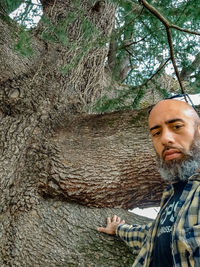 Portrait of man in tree trunk