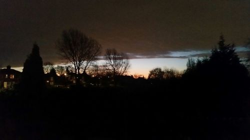 Silhouette trees against sky at sunset