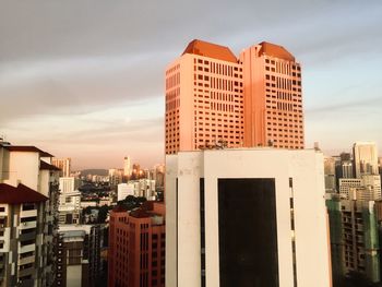 Modern buildings against sky during sunset